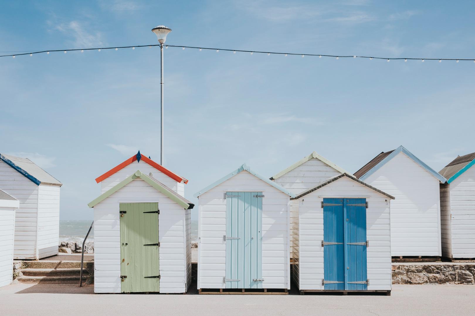 a line of five beach huts on Brighton promenade 5 beach huts are